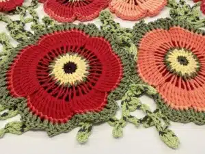 Vibrant crochet decor with poppy patterns in red and green.