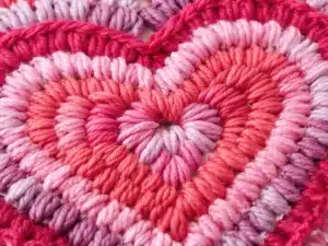 Crocheted heart in red and pink yarn.