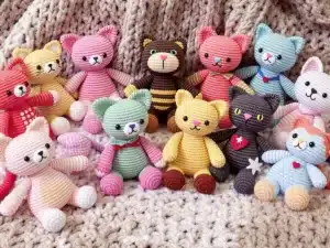 Colorful crochet cats in various cute poses.