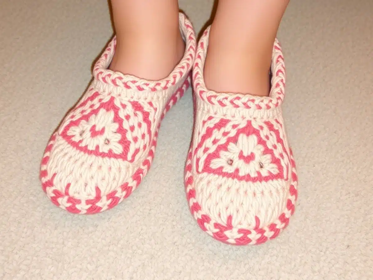 Handmade crochet slippers on a cozy carpet.