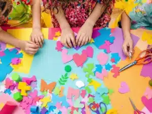 Kids creating colorful crafts with construction paper.