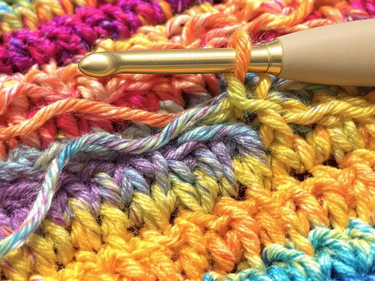 Colorful yarn and crochet hook with textured stitches. Treble Crochet